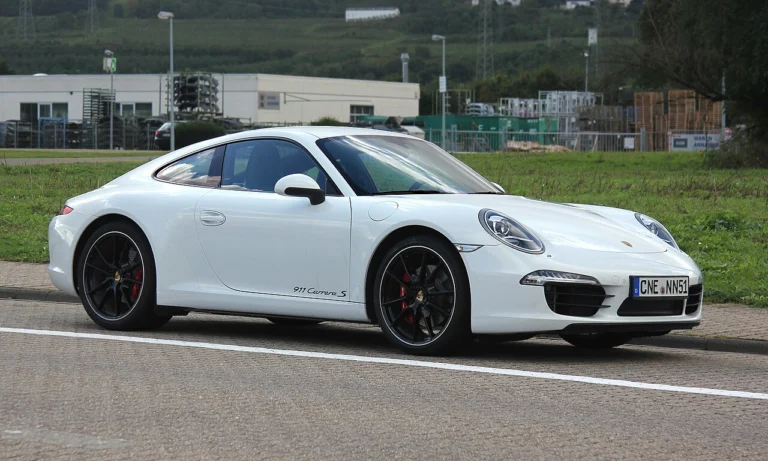 White Porsche 911 Carrera S Coupe parked beside a field