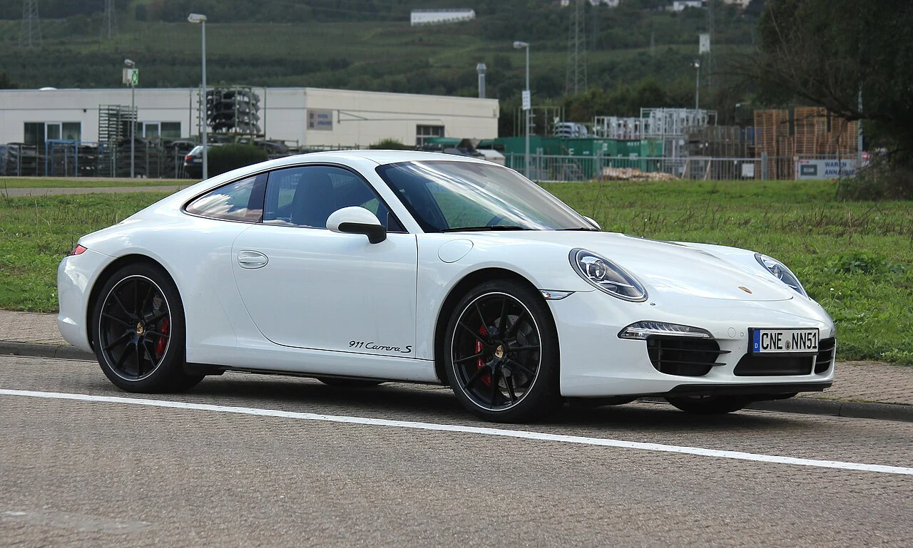 White Porsche 911 Carrera S Coupe parked beside a field