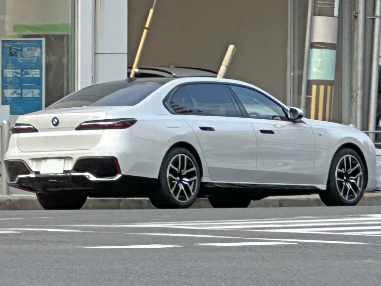 White BMW 740i sedan, rear three-quarter view