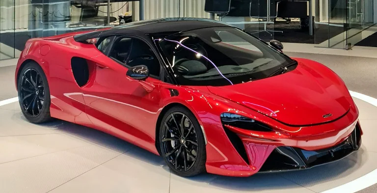 Red McLaren Artura Coupe displayed in a showroom