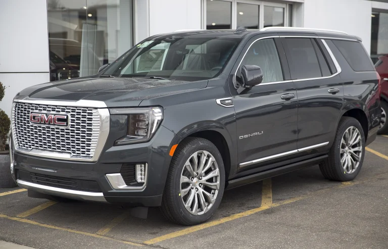 GMC Yukon Denali in Hunter Metallic, parked outside a dealership