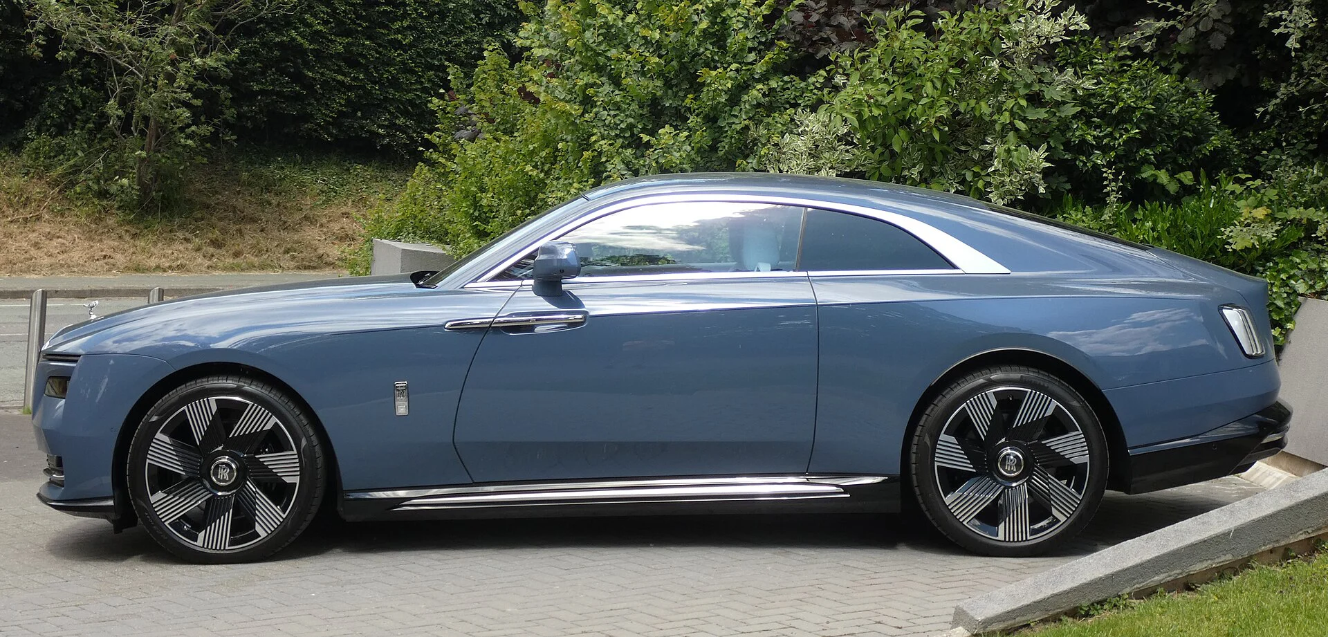 Side profile of a blue Rolls-Royce Spectre coupe