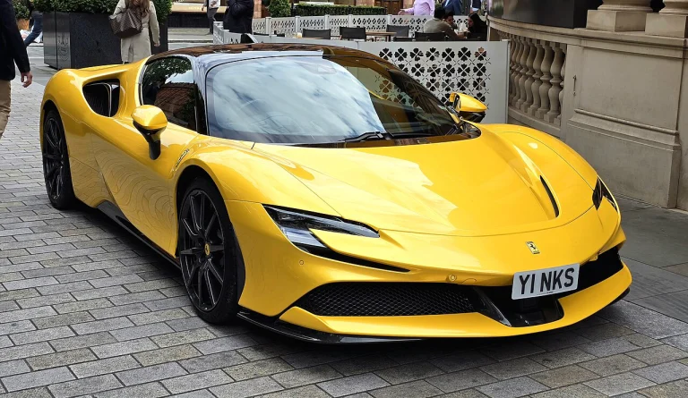 Yellow Ferrari SF90 coupe parked beside a building
