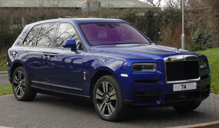 Blue Rolls-Royce Cullinan parked beside a road