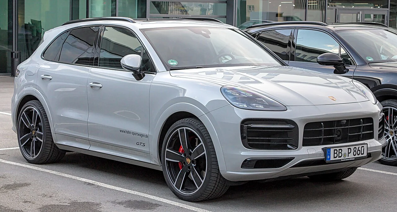Silver Porsche Cayenne GTS SUV parked outside a showroom