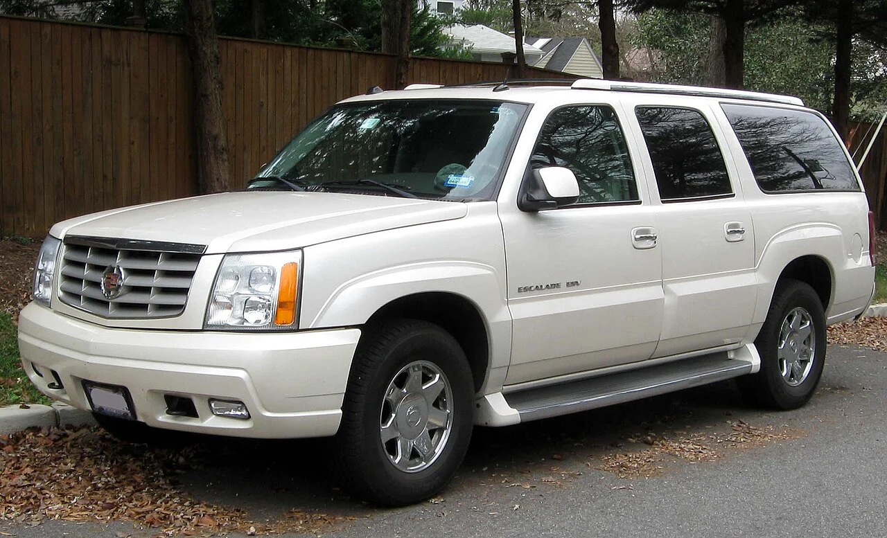 White Cadillac Escalade ESV parked beside a road