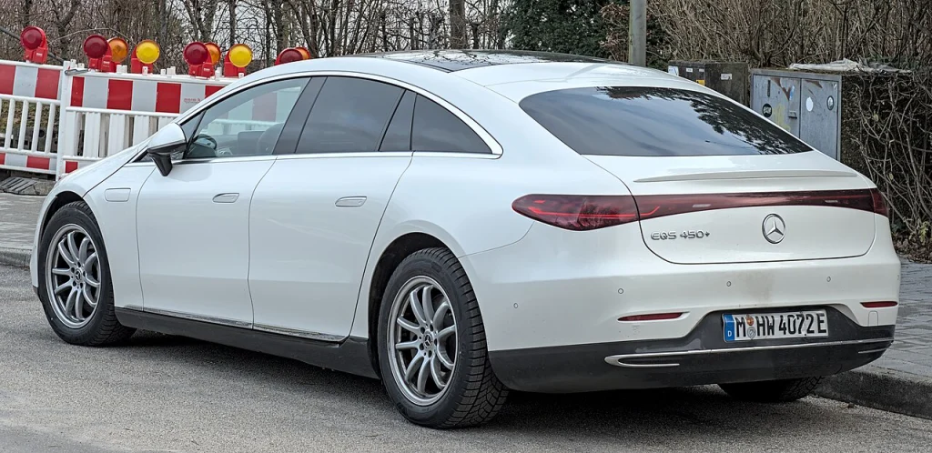 Rear three-quarter view of a white Mercedes-Benz EQS sedan