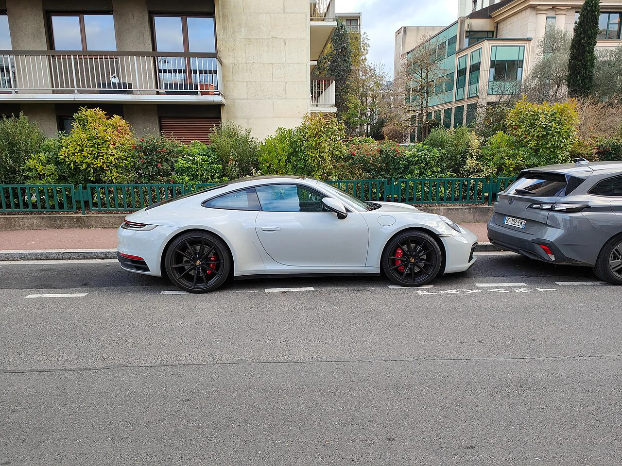 Side profile of a white Porsche 911 Carrera S parked on a street