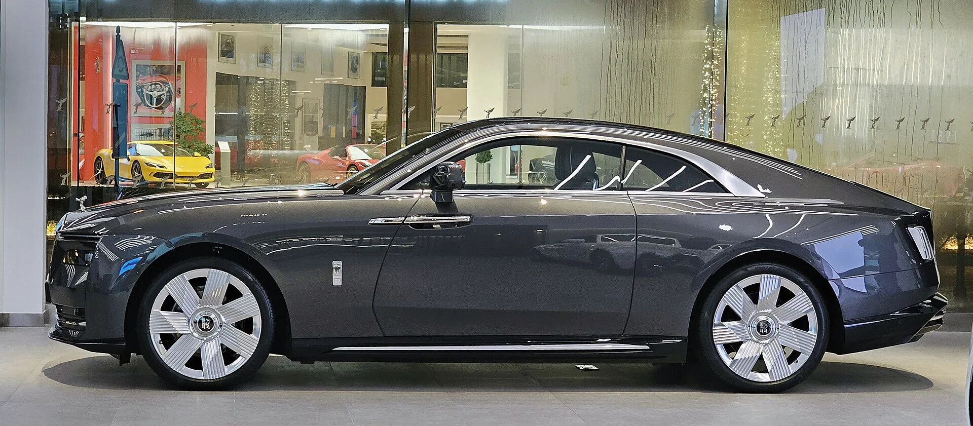 Side profile of an anthracite Rolls-Royce Spectre coupe